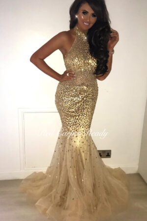 Sleeveless gold fishtail dress with crystal embellishments and a halter neckline.