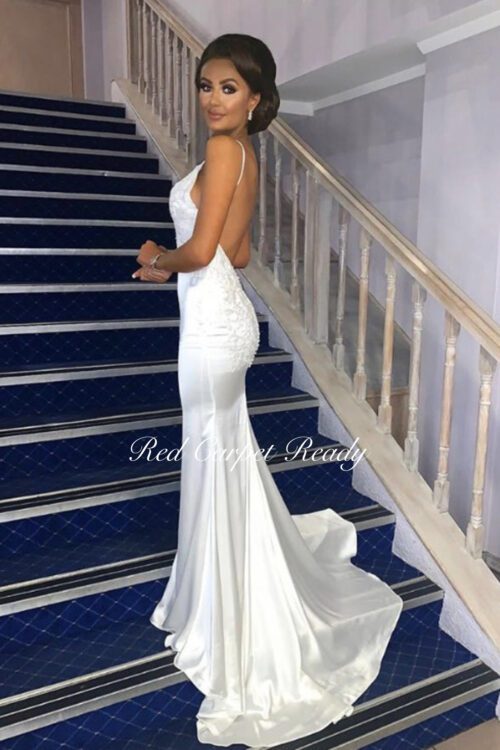 Tight fitting white dress with lace detailing, a train, open back and straps.