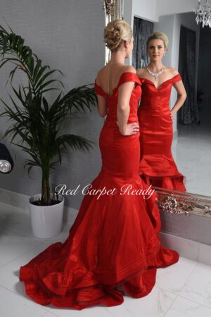 Red off-the-shoulder fishtail dress with a v-panel and tight-fitting bodice.