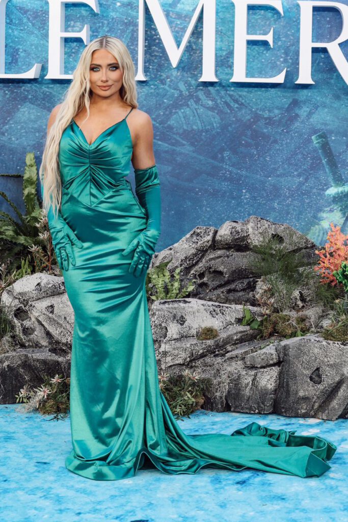 Saffron Barker wearing an emerald slinky evening dress with a flowing skirt to The Little Mermaid Premiere