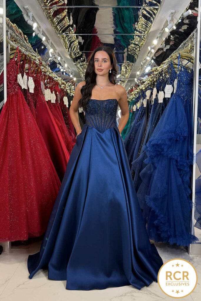 A navy strapless satin princess dress, with a corset structure top embellished with ombre jewels and zip back.