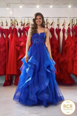 A royal blue tiered ruffle ball gown with delicate applique flowers on a detailed bodice with a corset back.